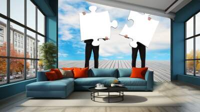 two men holding puzzles on wooden floor Wall mural