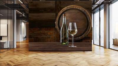 Glass of wine, bottle of light wine chardonnay in front of the rustic barrels for beverage in a dark wine cellar. Wooden empty surfaces for copy space, mockup, template for design of alcohol products Wall mural