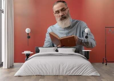 Senior charismatic man holding a book Wall mural