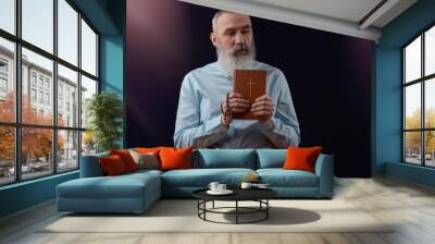 Senior charismatic man holding a book Wall mural