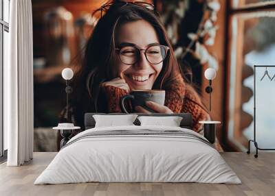 Beautiful young woman in a warm knitted sweater with a cup of coffee in her hands Wall mural