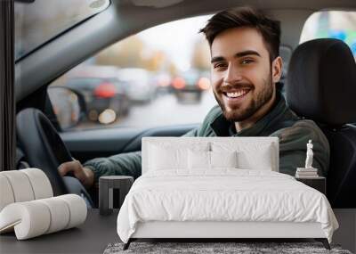 Handsome young man is driving a car and smiling driving a car with a clear view of the city through the window. showcasing safe driving with a seatbelt Wall mural