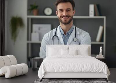 Portrait of handsome young male doctor in white coat and stethoscope standing in office Wall mural