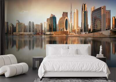 Dubai skyline with reflection at dramatic sunset with sun in United Arab Emirates Wall mural