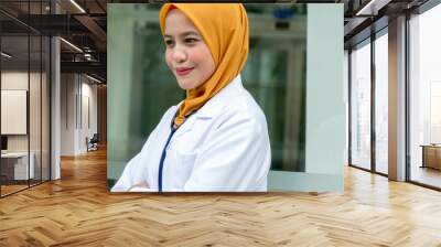 Confident female doctor standing infront of  office and smiling at camera, health care and prevention concept Wall mural