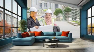 Professional woman engineers are discussing on construction at outdoor. Wall mural