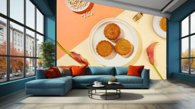 Background with coral and beige color featured two dishes of mooncakes and a dish of pumpkin seeds. Mid-Autumn Festival gradually becomes a family holiday Wall mural