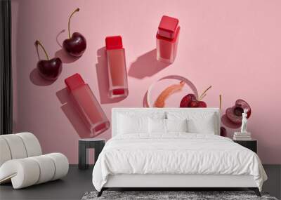 Scene for branding products. Red ripe cherries with lipsticks unbranded arranged on pink background. Cherries contain vitamin C and vitamin B, which help keep lips supple and safe for health Wall mural