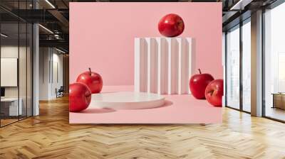 Some red apples displayed on a pink background with cylinder white podiums. Abstract background with minimalist style for product brand presentation. Advertising cosmetic from apple ingredient Wall mural