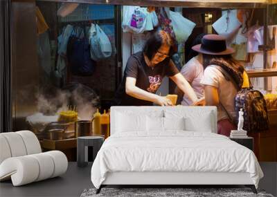 Travelers thai woman select and buy cuisine from Street Food in Hong Kong, China Wall mural