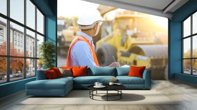 Asian engineer with hardhat using  tablet pc computer inspecting and working at construction site Wall mural