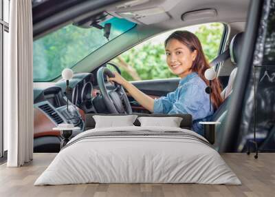 Beautiful Asian woman smiling and enjoying.driving a car on road for travel Wall mural