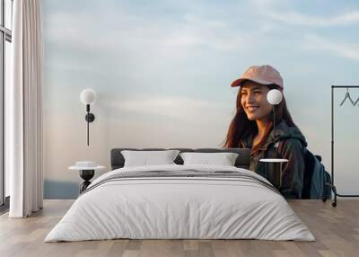 women asian with bright backpack looking at a map. View from back of the tourist traveler on background mountain, Female hands using smartphone, Wall mural