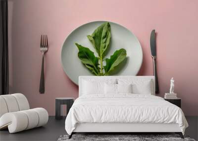 A green leaf lies on an empty white plate on the table. Light colors, diet and weight loss concept, eating disorders, calorie counting. Wall mural