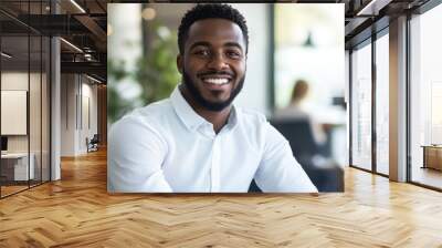 Confident job seeker smiling brightly while answering questions in a modern office setting Wall mural