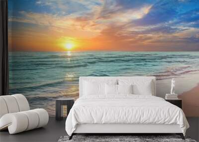 Colorful sunset viewed from the pink sea beach with soft waves Wall mural