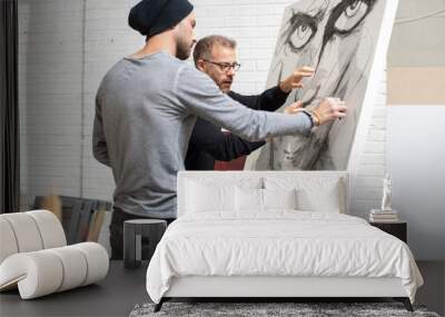 Artist discussing drawing with man in studio Wall mural