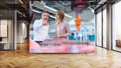 Businessman and businesswoman talking in a modern factory hall Wall mural