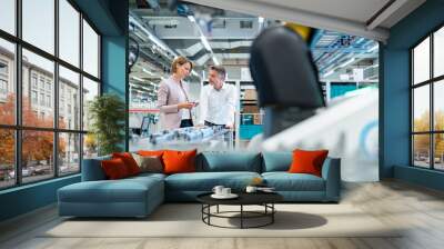 Businessman and businesswoman talking in a modern factory hall Wall mural