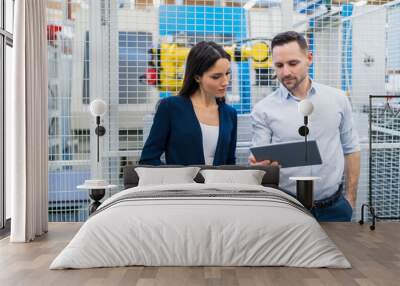 Businessman and businesswoman using tablet in modern factory Wall mural