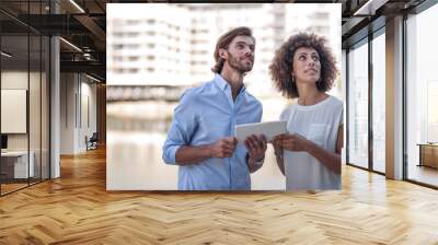 Businessman and woman having a meeting outdoors, using digital tablet Wall mural