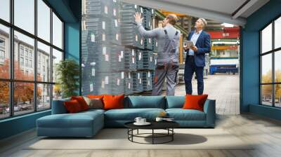 Businessman and worker talking in a factory storehouse Wall mural