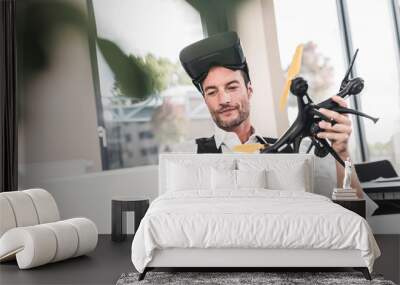 Businessman sitting in office working on a drone, using VR glasses Wall mural