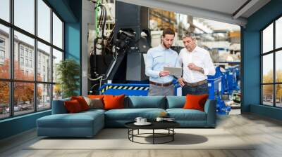 Businessmen using tablet during meeting in production hall Wall mural