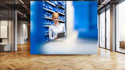 Businesswoman with tablet in factory storehouse Wall mural