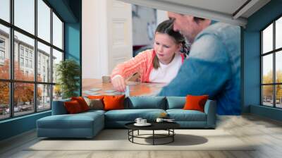 Father and daughter playing memory on table at home Wall mural