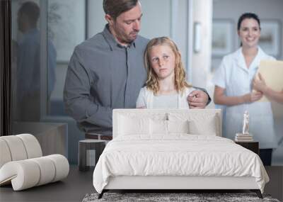 Father guiding sick daughter in hospital Wall mural