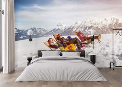 Friends sunbathing in deck chairs in mountainscape in winter, Achenkirch, Austria Wall mural