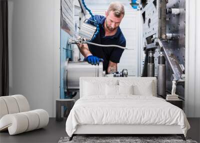 Man working on machine in industrial factory Wall mural