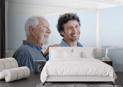 Portrait of confident senior man with adult son at a beach house Wall mural