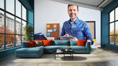 Portrait of smiling man using tablet in office Wall mural