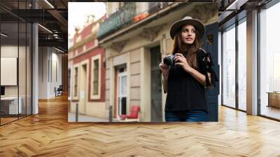 Portrait of smiling young woman with camera outdoors Wall mural