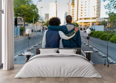 Rear view of two men embracing on the street in the city, Barcelona, Spain Wall mural