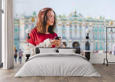 Russia, St. Petersburg, young woman using smartphone in the city Wall mural