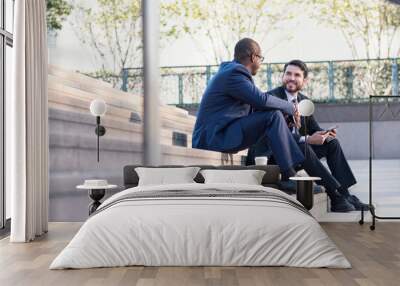 Two businessmen sitting on stairs talking Wall mural