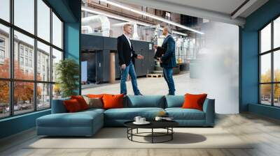 Two businessmen talking in a factory Wall mural