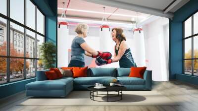 Two happy senior women with boxing gloves in gym Wall mural