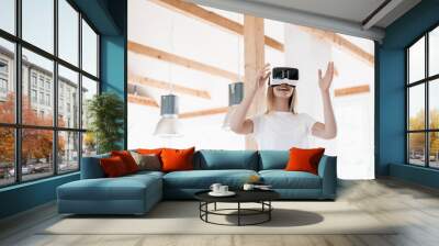 Young woman wearing VR goggles, designing her new home Wall mural