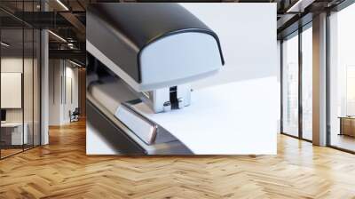 Closeup of a grey office stapler stapling white paper Wall mural