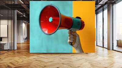 Amplifying Voices: Person Holding Megaphone on Vibrant Color Background Wall mural