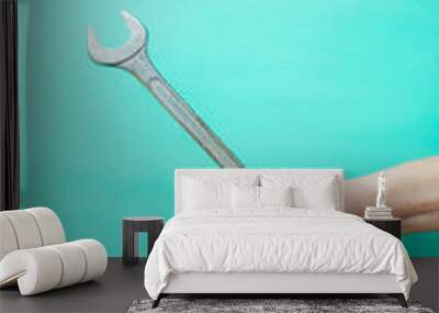 wrench in hands, on a blue background Wall mural