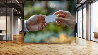 Two Hands Holding a Blank White Card with a Blurred Green Background Wall mural