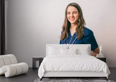 cheerful young female doctor with stethoscope over neck looking at camera isolated on white Wall mural