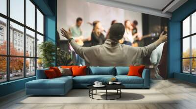 Hands in the air of a woman who praise God at church service Wall mural