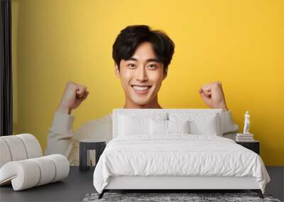 Portrait of a fictional young Korean guy in a happy victory pose. Isolated on yellow background. Generative AI illustration. Wall mural