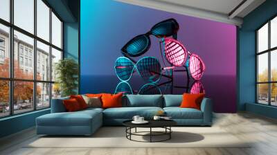 Sunglasses stacked in a pile with vivid color, hot pink and blue. Wall mural